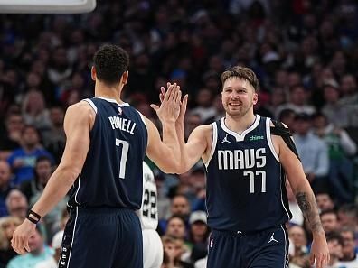 DALLAS, TX - DECEMBER 23: Luka Doncic #77 of the Dallas Mavericks high-fives Dwight Powell #7 during the game against the San Antonio Spurs on December 23, 2023 at the American Airlines Center in Dallas, Texas. NOTE TO USER: User expressly acknowledges and agrees that, by downloading and or using this photograph, User is consenting to the terms and conditions of the Getty Images License Agreement. Mandatory Copyright Notice: Copyright 2023 NBAE (Photo by Glenn James/NBAE via Getty Images)