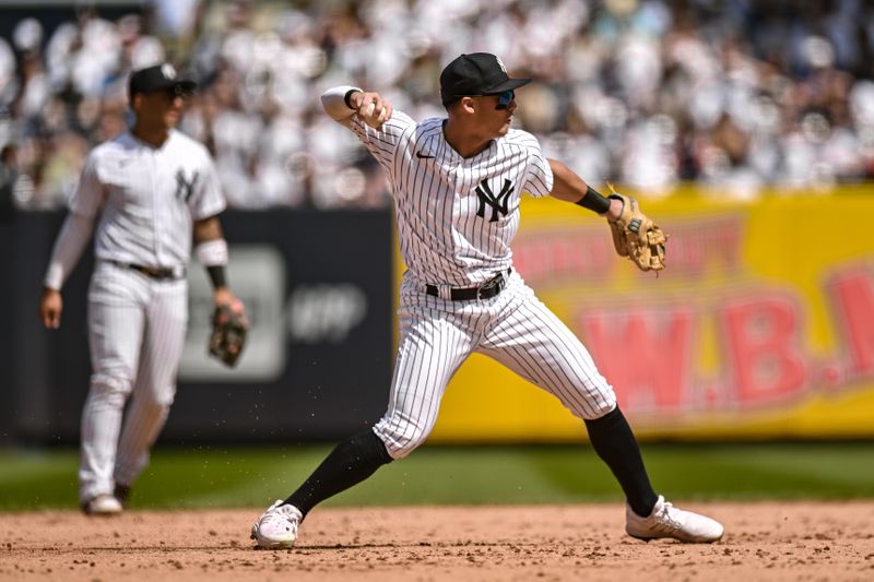 May 27, 2023; Bronx, New York, USA; New York Yankees shortstop Anthony Volpe (11) fields a ground ball and throws to first base for an out during the ninth inning against the San Diego Padres at Yankee Stadium. Mandatory Credit: John Jones-USA TODAY Sports