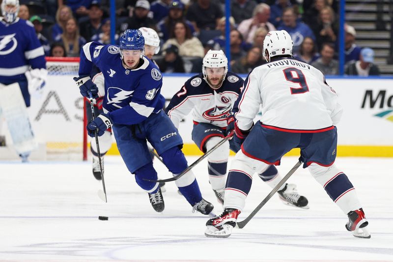 Mar 4, 2025; Tampa, Florida, USA; Tampa Bay Lightning center Gage Goncalves (93) controls the puck from Columbus Blue Jackets defenseman Ivan Provorov (9) in the second period at Amalie Arena. Mandatory Credit: Nathan Ray Seebeck-Imagn Images