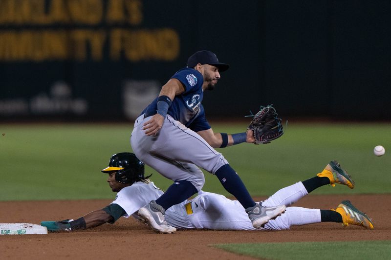 Sep 18, 2023; Oakland, California, USA;  Oakland Athletics center fielder Esteury Ruiz (1) slides during the eighth inning against Seattle Mariners second baseman Jose Caballero (76) at Oakland-Alameda County Coliseum. Mandatory Credit: Stan Szeto-USA TODAY Sports