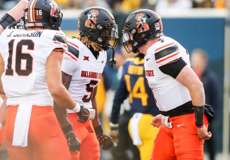 Oct 21, 2023; Morgantown, West Virginia, USA; Oklahoma State Cowboys wide receiver Jaden Bray (5) celebrates with Oklahoma State Cowboys quarterback Alan Bowman (7) after connecting for a touchdown during the third quarter against the West Virginia Mountaineers at Mountaineer Field at Milan Puskar Stadium. Mandatory Credit: Ben Queen-USA TODAY Sports