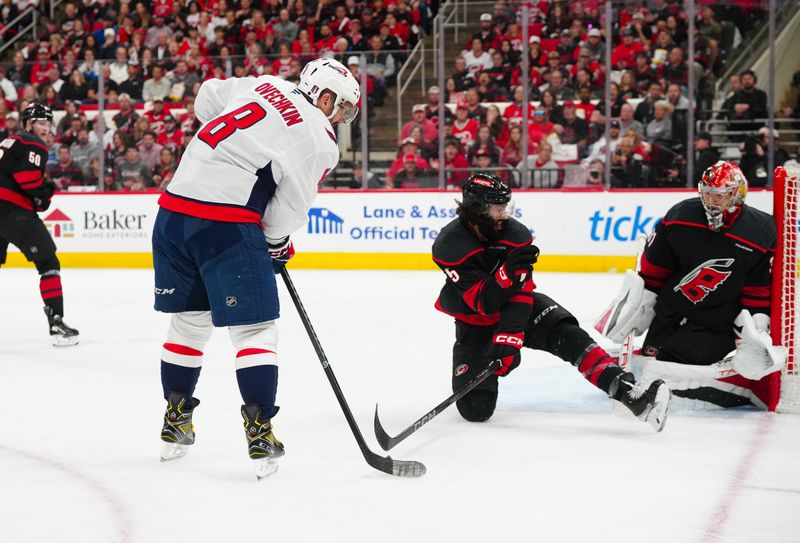May 12, 2025; Raleigh, North Carolina, USA; Washington Capitals left wing Alex Ovechkin (8) tries to get the shot away against Carolina Hurricanes defenseman Jalen Chatfield (5) and goaltender Frederik Andersen (31) during the second period in game four of the second round of the 2025 Stanley Cup Playoffs at Lenovo Center. Mandatory Credit: James Guillory-Imagn Images