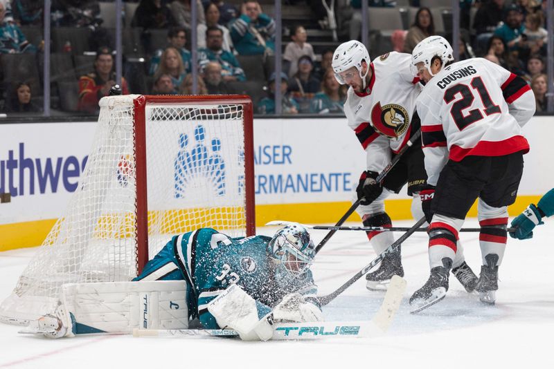 Nov 22, 2025; San Jose, California, USA;  San Jose Sharks goaltender Alex Nedeljkovic (33) defends the goal during the third period against Ottawa Senators right wing Drake Batherson (19) and center Nick Cousins (21) at SAP Center at San Jose. Mandatory Credit: Stan Szeto-Imagn Images