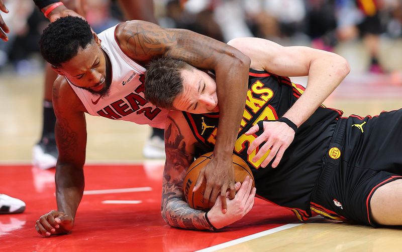 ATLANTA, GEORGIA - APRIL 09:  Vit Krejci #27 of the Atlanta Hawks is charged with a foul as he dives for the ball against Haywood Highsmith #24 of the Miami Heat during overtime at State Farm Arena on April 09, 2024 in Atlanta, Georgia.  NOTE TO USER: User expressly acknowledges and agrees that, by downloading and/or using this photograph, user is consenting to the terms and conditions of the Getty Images License Agreement.  (Photo by Kevin C. Cox/Getty Images)