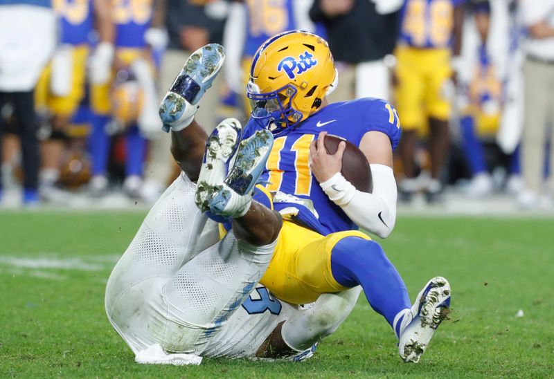 Sep 23, 2023; Pittsburgh, Pennsylvania, USA; North Carolina Tar Heels linebacker Cedric Gray (left) sacks Pittsburgh Panthers quarterback Christian Veilleux (11) during the third quarter at Acrisure Stadium. Mandatory Credit: Charles LeClaire-USA TODAY Sports