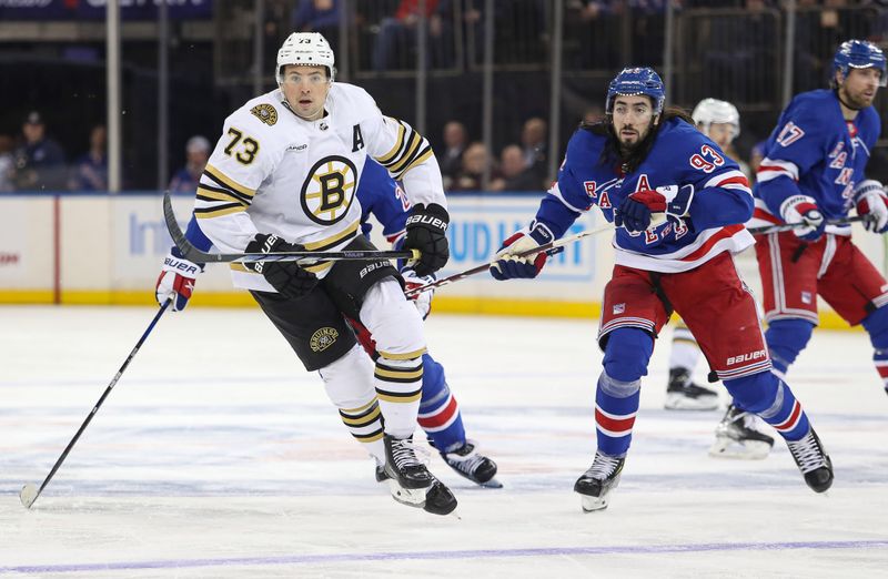 Nov 25, 2023; New York, New York, USA; Boston Bruins defenseman Charlie McAvoy (73) and New York Rangers center Mika Zibanejad (93) skate up ice during the third period at Madison Square Garden. Mandatory Credit: Danny Wild-USA TODAY Sports