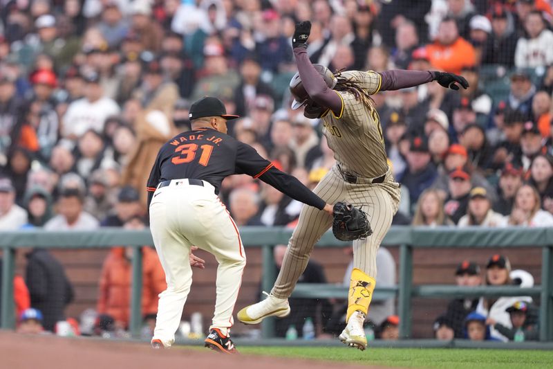 Apr 6, 2024; San Francisco, California, USA; San Diego Padres right fielder Fernando Tatis Jr. (right) is called safe after avoiding the tag of San Francisco Giants first baseman LaMonte Wade Jr. (31) for a single during the third inning at Oracle Park. The call was overturned to an out after a video review.  Mandatory Credit: Darren Yamashita-USA TODAY Sports