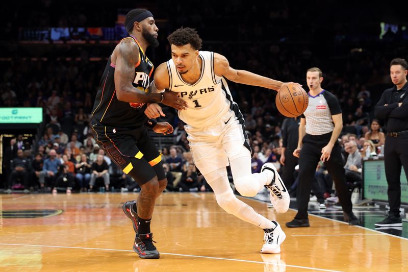 PHOENIX, ARIZONA - DECEMBER 03: Victor Wembanyama #1 of the San Antonio Spurs drives to the basket against Royce O'Neale #00 of the Phoenix Suns during the second half of the Emirates NBA Cup game at Footprint Center on December 03, 2024 in Phoenix, Arizona. NOTE TO USER: User expressly acknowledges and agrees that, by downloading and or using this photograph, User is consenting to the terms and conditions of the Getty Images License Agreement.  (Photo by Chris Coduto/Getty Images)