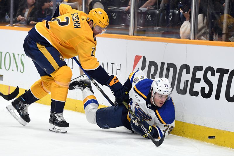 Apr 4, 2024; Nashville, Tennessee, USA; St. Louis Blues left wing Sammy Blais (79) tries to play the puck after being hit by Nashville Predators defenseman Luke Schenn (2) during the second period at Bridgestone Arena. Mandatory Credit: Christopher Hanewinckel-USA TODAY Sports