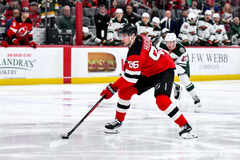 Oct 22, 2025; Newark, New Jersey, USA; New Jersey Devils center Jack Hughes (86) skates with the puck while defended by Minnesota Wild center Marco Rossi (23) during the second period at Prudential Center. Mandatory Credit: John Jones-Imagn Images
