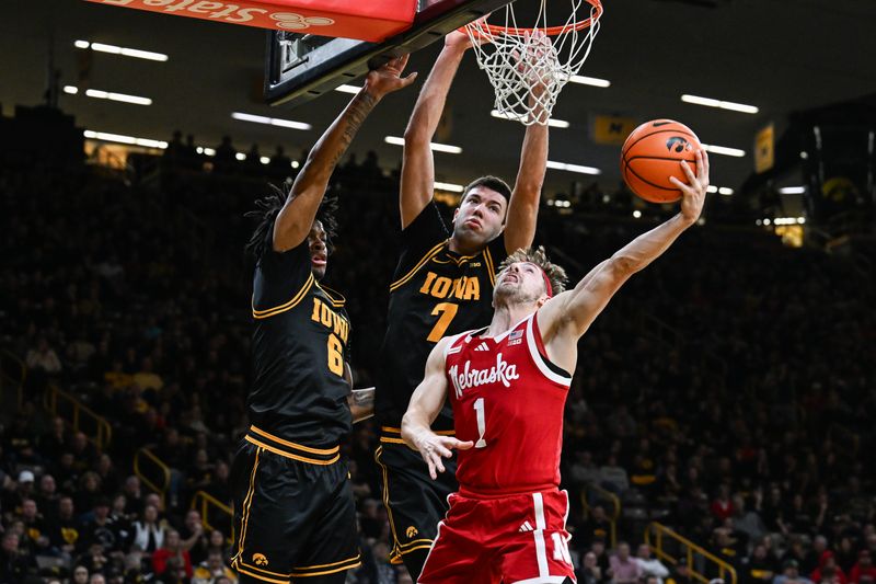 Feb 17, 2026; Iowa City, Iowa, USA; Nebraska Cornhuskers guard Sam Hoiberg (1) goes to the basket as Iowa Hawkeyes forward Alvaro Folgueiras (rear) and guard Tavion Banks (6) defend during the first half at Carver-Hawkeye Arena. Mandatory Credit: Jeffrey Becker-Imagn Images