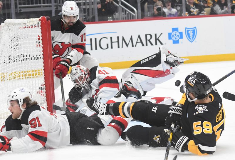 Nov 16, 2023; Pittsburgh, Pennsylvania, USA; Pittsburgh Penguins left wing Jake Guentzel (58) crashes into New Jersey Devils goalie Vitek Vanecek (41) and center Dawson Mercer (91) during the first period at PPG Paints Arena. Mandatory Credit: Philip G. Pavely-USA TODAY Sports