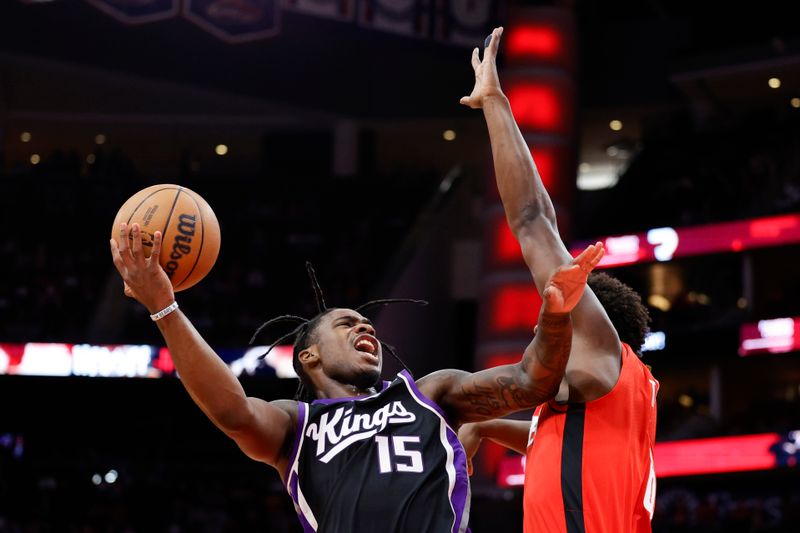 HOUSTON, TEXAS - NOVEMBER 06: Davion Mitchell #15 of the Sacramento Kings drives to the basket over Jae'Sean Tate #8 of the Houston Rockets during the first half at Toyota Center on November 06, 2023 in Houston, Texas. (Photo by Carmen Mandato/Getty Images)