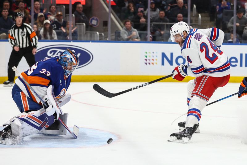 Dec 27, 2025; Elmont, New York, USA;  New York Islanders goaltender David Rittich (33) makes a save on a shot on goal attempt from New York Rangers defenseman Carson Soucy (24) in the third period at UBS Arena. Mandatory Credit: Wendell Cruz-Imagn Images
