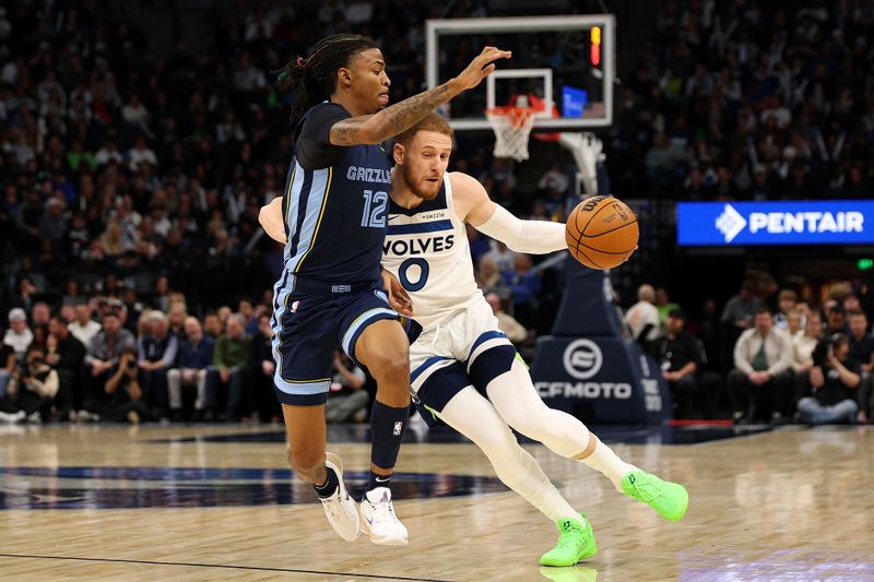 MINNEAPOLIS, MINNESOTA - JANUARY 11: Donte DiVincenzo #0 of the Minnesota Timberwolves drives to the basket against Ja Morant #12 of the Memphis Grizzlies in the first quarter at Target Center on January 11, 2025 in Minneapolis, Minnesota. NOTE TO USER: User expressly acknowledges and agrees that, by downloading and or using this photograph, User is consenting to the terms and conditions of the Getty Images License Agreement. (Photo by David Berding/Getty Images)