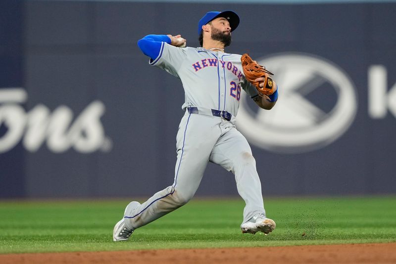 Sep 10, 2024; Toronto, Ontario, CAN; New York Mets second baseman Eddy Alvarez (26) makes an off balance throw to first base on a ground ball hit by Toronto Blue Jays right fielder George Springer (not pictured) during the first inning at Rogers Centre. Mandatory Credit: John E. Sokolowski-Imagn Images