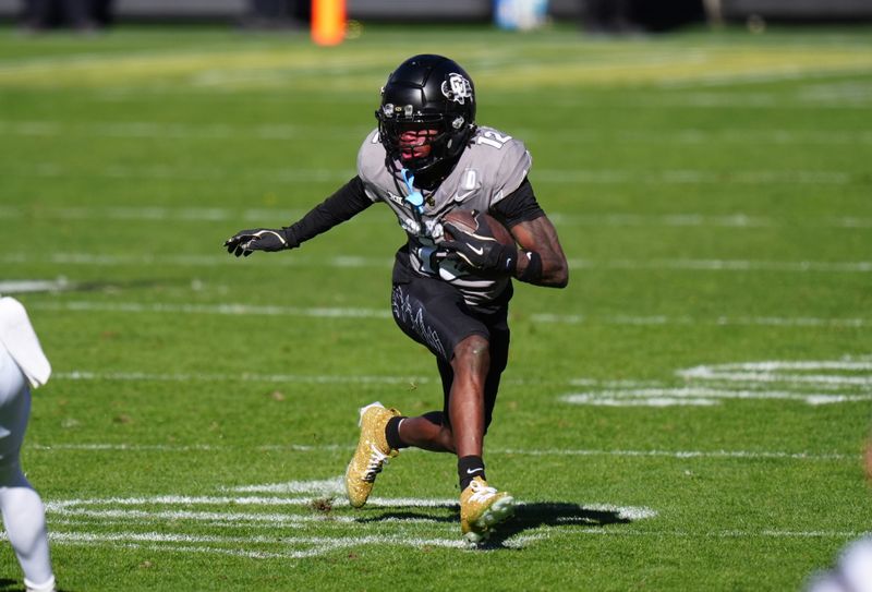 Nov 16, 2024; Boulder, Colorado, USA; Colorado Buffaloes wide receiver Travis Hunter (12) carries the ball in the second quarter against the Utah Utes at Folsom Field. Mandatory Credit: Ron Chenoy-Imagn Images