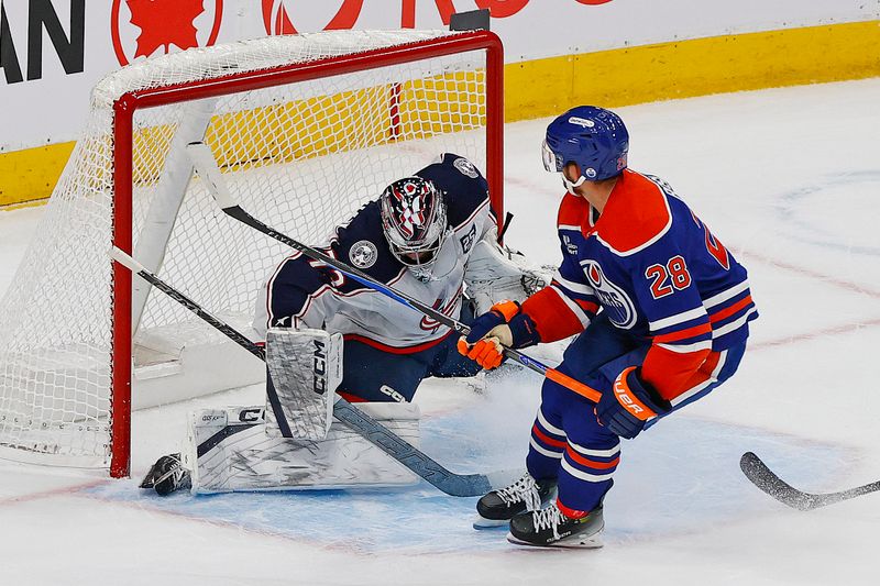 Nov 10, 2025; Edmonton, Alberta, CAN; Edmonton Oilers forward Jack Roslovic (28) scores during overtime against Columbus Blue Jackets goaltender Jet Greaves (73)  at Rogers Place. Mandatory Credit: Perry Nelson-Imagn Images