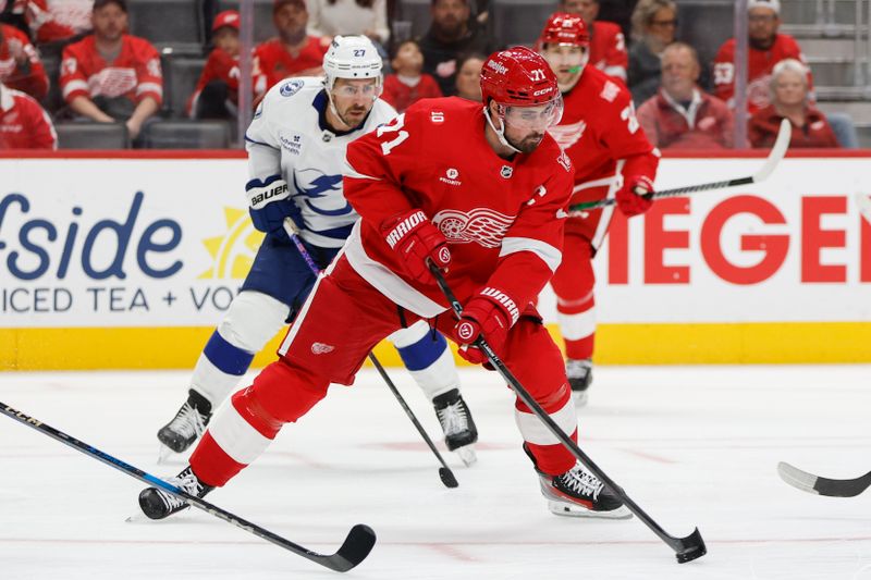 Oct 17, 2025; Detroit, Michigan, USA; Detroit Red Wings center Dylan Larkin (71) handles the puck closely followed by Tampa Bay Lightning defenseman Ryan McDonagh (27) during the second period at Little Caesars Arena. Mandatory Credit: Brian Bradshaw Sevald-Imagn Images