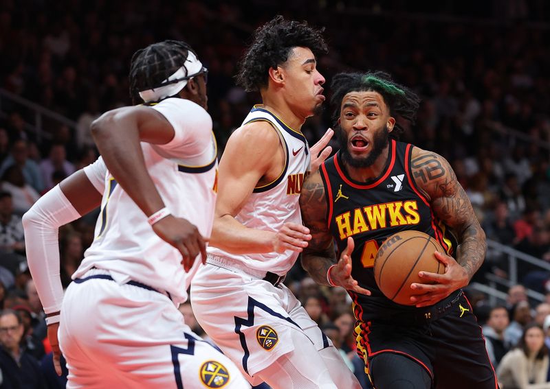 ATLANTA, GEORGIA - DECEMBER 11:  Saddiq Bey #41 of the Atlanta Hawks attacks the basket against Julian Strawther #3 Reggie Jackson #7 of the Denver Nuggets during the fourth quarter at State Farm Arena on December 11, 2023 in Atlanta, Georgia.  NOTE TO USER: User expressly acknowledges and agrees that, by downloading and/or using this photograph, user is consenting to the terms and conditions of the Getty Images License Agreement.  (Photo by Kevin C. Cox/Getty Images)