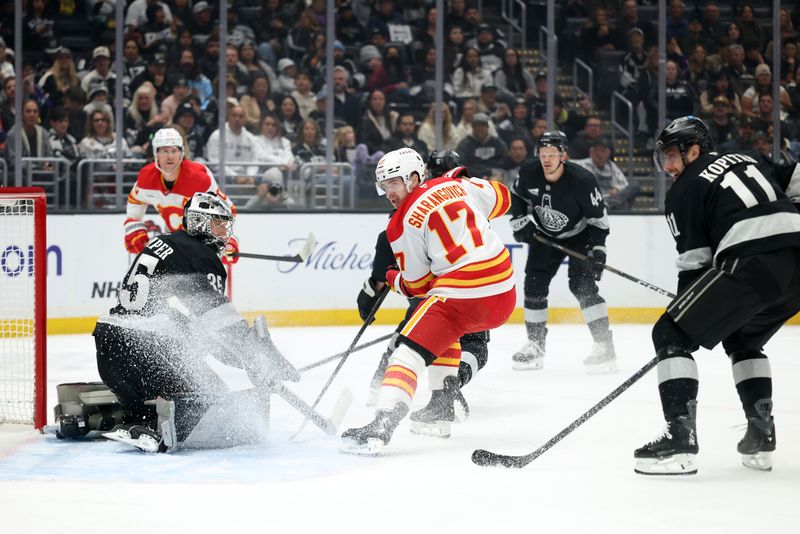Dec 13, 2025; Los Angeles, California, USA;  Los Angeles Kings goaltender Darcy Kuemper (35) protects the goal against Calgary Flames center Yegor Sharangovich (17) during the first period at Crypto.com Arena. Mandatory Credit: Kiyoshi Mio-Imagn Images