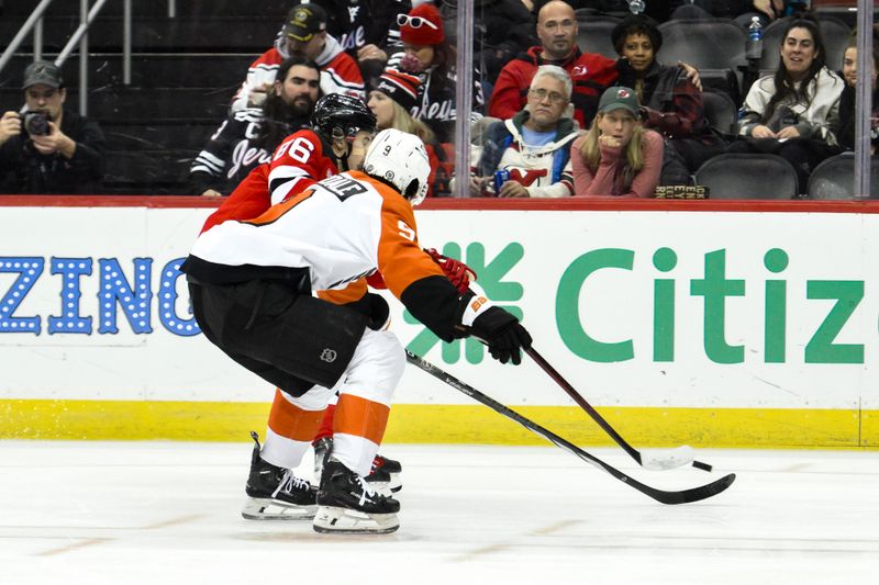 Jan 29, 2025; Newark, New Jersey, USA; New Jersey Devils center Jack Hughes (86) skates with the puck against Philadelphia Flyers defenseman Jamie Drysdale (9) during the third period at Prudential Center. Mandatory Credit: John Jones-Imagn Images