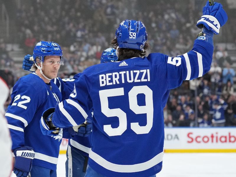 Feb 17, 2024; Toronto, Ontario, CAN; Toronto Maple Leafs defenseman Jake McCabe (22) scores a goal and celebrates with left wing Todd Bertuzzi (59) during the first period against the Anaheim Ducks at Scotiabank Arena. Mandatory Credit: Nick Turchiaro-USA TODAY Sports