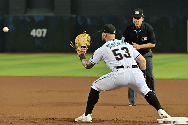 May 10, 2023; Phoenix, Arizona, USA; Arizona Diamondbacks first baseman Christian Walker (53) catches a ball at first base as umpire Phil Cuzzi (10) watches in the first inning against the Miami Marlins at Chase Field. Mandatory Credit: Matt Kartozian-USA TODAY Sports