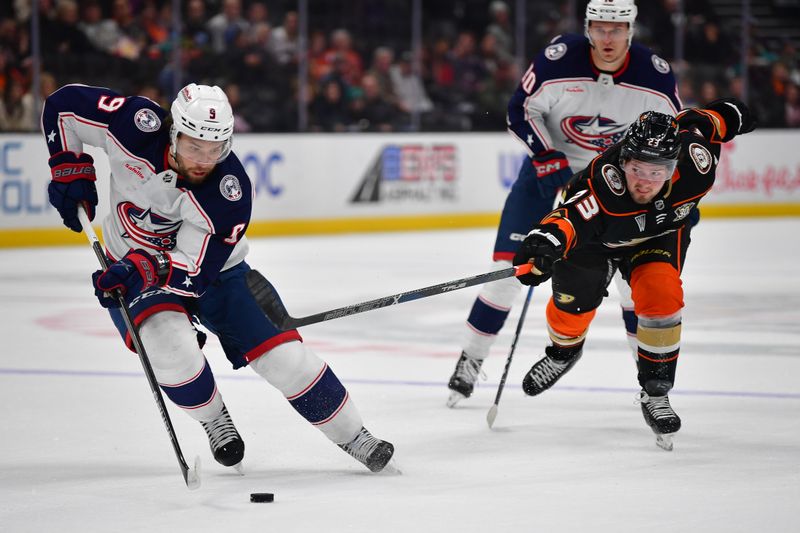 Feb 21, 2024; Anaheim, California, USA; Anaheim Ducks center Mason McTavish (23) plays for the puck against Columbus Blue Jackets defenseman Ivan Provorov (9) during the first period at Honda Center. Mandatory Credit: Gary A. Vasquez-USA TODAY Sports