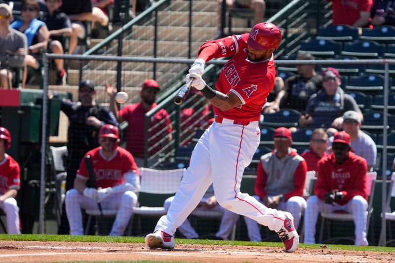 Mar 22, 2024; Tempe, Arizona, USA; Los Angeles Angels center fielder Aaron Hicks (12) hits a single against the Chicago White Sox in the first inning at Tempe Diablo Stadium. Mandatory Credit: Rick Scuteri-USA TODAY Sports