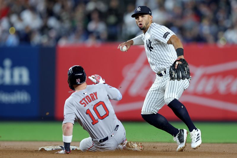 Jun 7, 2025; Bronx, New York, USA; New York Yankees shortstop Oswald Peraza (18) forces out Boston Red Sox shortstop Trevor Story (10) at second base and throws to first to complete a double play on a ball hit by Red Sox center fielder Ceddanne Rafaela (not pictured) during the seventh inning at Yankee Stadium. Mandatory Credit: Brad Penner-Imagn Images