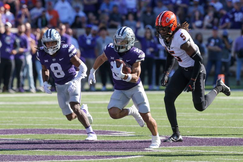 Oct 29, 2022; Manhattan, Kansas, USA; Kansas State Wildcats running back Deuce Vaughn (22) runs by Oklahoma State Cowboys safety Kendal Daniels (5) on his way to a touchdown in the first quarter at Bill Snyder Family Football Stadium. Mandatory Credit: Scott Sewell-USA TODAY Sports