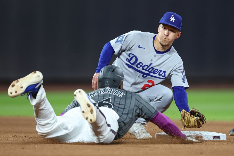 May 25, 2025; New York City, New York, USA;  Los Angeles Dodgers center fielder Tommy Edman (25) tags out New York Mets left fielder Starling Marte (6) on an attempted steal at first base during the seventh inning at Citi Field. Mandatory Credit: Vincent Carchietta-Imagn Images