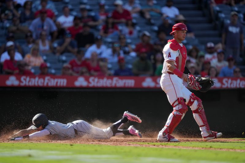 Sep 18, 2024; Anaheim, California, USA; Chicago White Sox second baseman Jacob Amaya (18) slides into home plate to beat a throw to Los Angeles Angels catcher Logan O'Hoppe (14) to score in the 11th inning at Angel Stadium. Mandatory Credit: Kirby Lee-Imagn Images