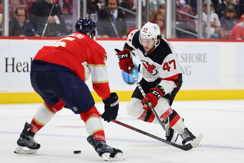 Nov 12, 2024; Sunrise, Florida, USA; New Jersey Devils center Paul Cotter (47) movers the puck against Florida Panthers defenseman Aaron Ekblad (5) during the first period at Amerant Bank Arena. Mandatory Credit: Sam Navarro-Imagn Images