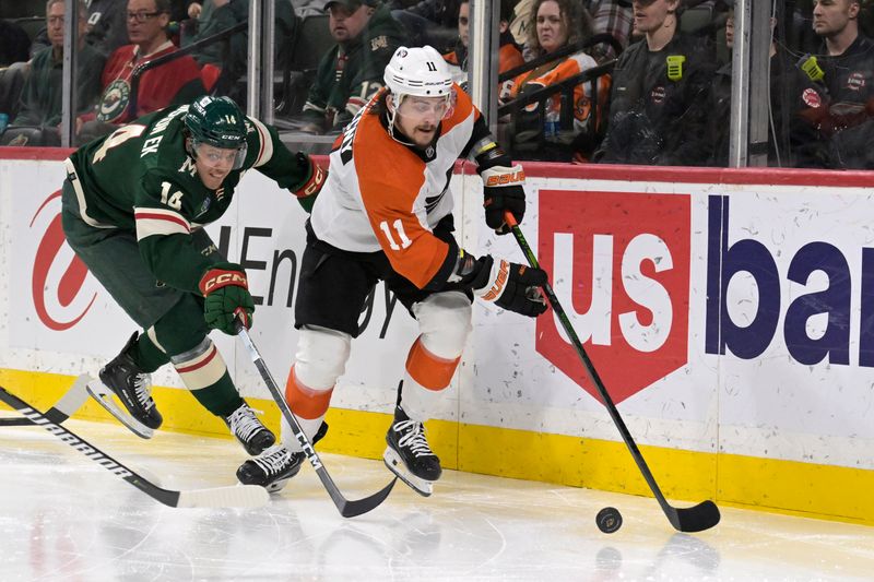 Jan 12, 2024; Saint Paul, Minnesota, USA; Philadelphia Flyers forward Travis Konecny (11) controls the puck as Minnesota Wild forward Joel Eriksson Ek (14) gives chase during the third period at Xcel Energy Center. Mandatory Credit: Nick Wosika-USA TODAY Sports