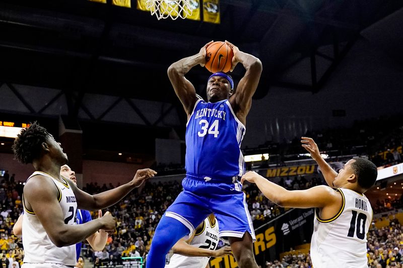 Dec 28, 2022; Columbia, Missouri, USA; Kentucky Wildcats forward Oscar Tshiebwe (34) grabs a rebound against Missouri Tigers guard Kobe Brown (24) and guard Nick Honor (10) during the first half at Mizzou Arena. Mandatory Credit: Jay Biggerstaff-USA TODAY Sports