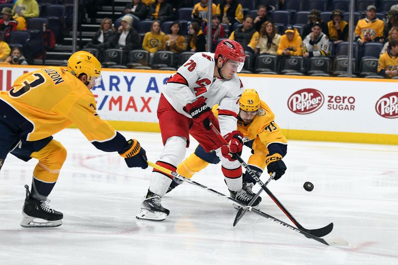 Dec 27, 2023; Nashville, Tennessee, USA; Carolina Hurricanes defenseman Brady Skjei (76) has the puck knocked away by Nashville Predators defenseman Alexandre Carrier (45) and defenseman Jeremy Lauzon (3) on a play during the second period at Bridgestone Arena. Mandatory Credit: Christopher Hanewinckel-USA TODAY Sports