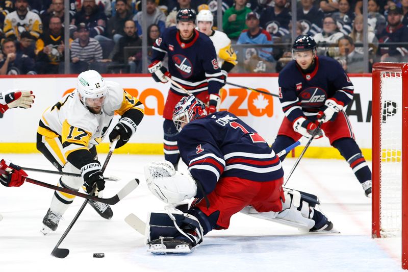 Oct 20, 2024; Winnipeg, Manitoba, CAN; Pittsburgh Penguins right wing Bryan Rust (17) shoots on Winnipeg Jets goaltender Eric Comrie (1) in the first period at Canada Life Centre. Mandatory Credit: James Carey Lauder-Imagn Images