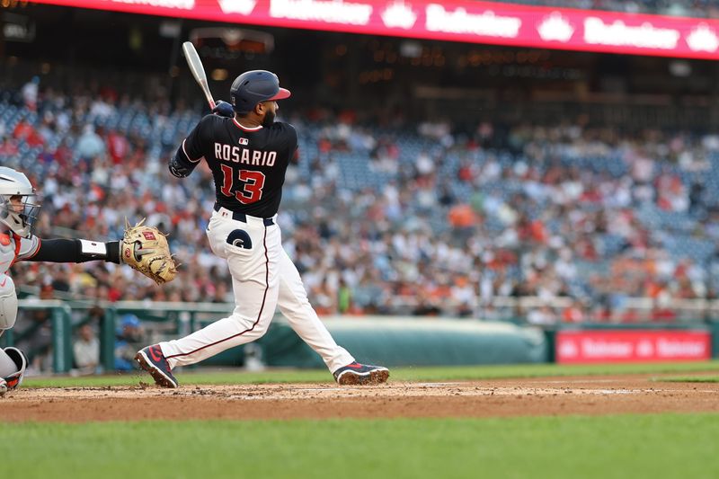Apr 24, 2025; Washington, District of Columbia, USA; Washington Nationals third base Amed Rosario (13) doubles against the Baltimore Orioles during the second inning at Nationals Park. Mandatory Credit: Geoff Burke-Imagn Images
