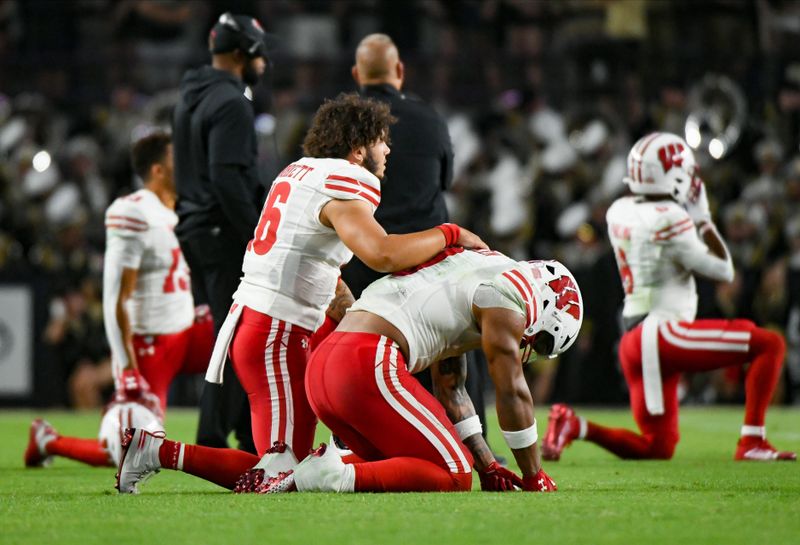 Sep 22, 2023; West Lafayette, Indiana, USA;  Wisconsin Badgers quarterback Myles Burkett (16) consoles Wisconsin Badgers running back Braelon Allen (0) after an injury to Wisconsin Badgers running back Chez Mellusi (1) during the second half at Ross-Ade Stadium. Mandatory Credit: Robert Goddin-USA TODAY Sports