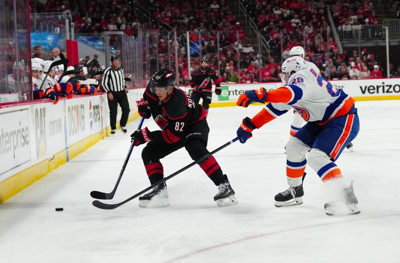 Apr 20, 2024; Raleigh, North Carolina, USA; Carolina Hurricanes center Evgeny Kuznetsov (92) skates with the puck past New York Islanders defenseman Alexander Romanov (28) during the first period in game one of the first round of the 2024 Stanley Cup Playoffs at PNC Arena. Mandatory Credit: James Guillory-USA TODAY Sports