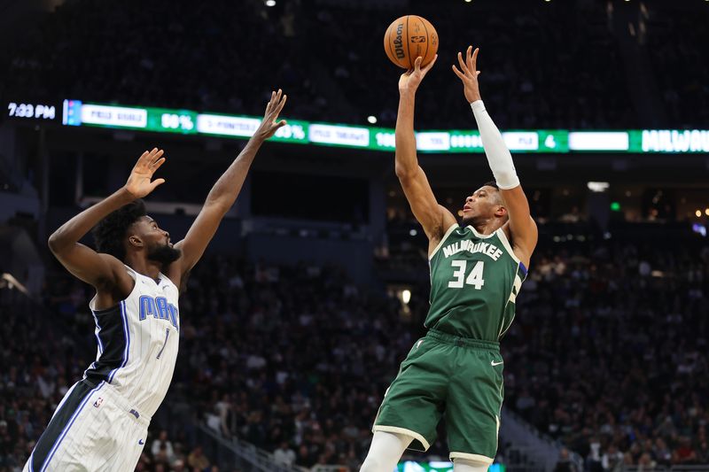 MILWAUKEE, WISCONSIN - DECEMBER 21: Giannis Antetokounmpo #34 of the Milwaukee Bucks shoots over Jonathan Isaac #1 of the Orlando Magic during a game at Fiserv Forum on December 21, 2023 in Milwaukee, Wisconsin. NOTE TO USER: User expressly acknowledges and agrees that, by downloading and or using this photograph, User is consenting to the terms and conditions of the Getty Images License Agreement. (Photo by Stacy Revere/Getty Images)