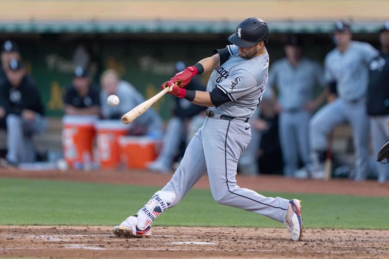 Aug 6, 2024; Oakland, California, USA;  Chicago White Sox outfielder Andrew Benintendi (23) hits a two run home run during the fourth inning against the Oakland Athletics at Oakland-Alameda County Coliseum. Mandatory Credit: Stan Szeto-USA TODAY Sports