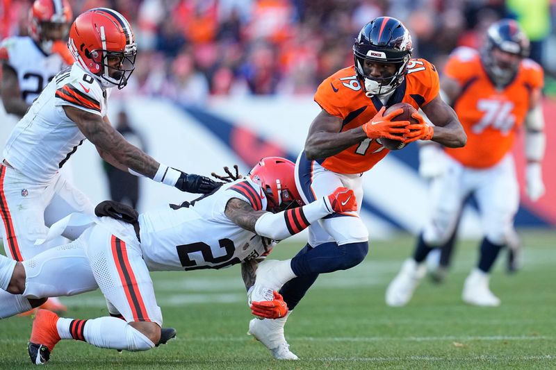 Denver Broncos wide receiver Marvin Mims Jr. (19) catches a pass for a first down as Cleveland Browns cornerback Mike Ford (28) and cornerback Greg Newsome II (0) defend during the first half of an NFL football game on Sunday, Nov. 26, 2023, in Denver. (AP Photo/Jack Dempsey)