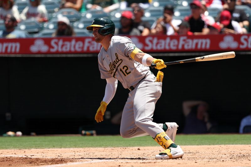 Jun 26, 2024; Anaheim, California, USA;  Oakland Athletics shortstop Max Schuemann (12) hits an RBI double against the Los Angeles Angels during the second inning at Angel Stadium. Mandatory Credit: Kiyoshi Mio-USA TODAY Sports