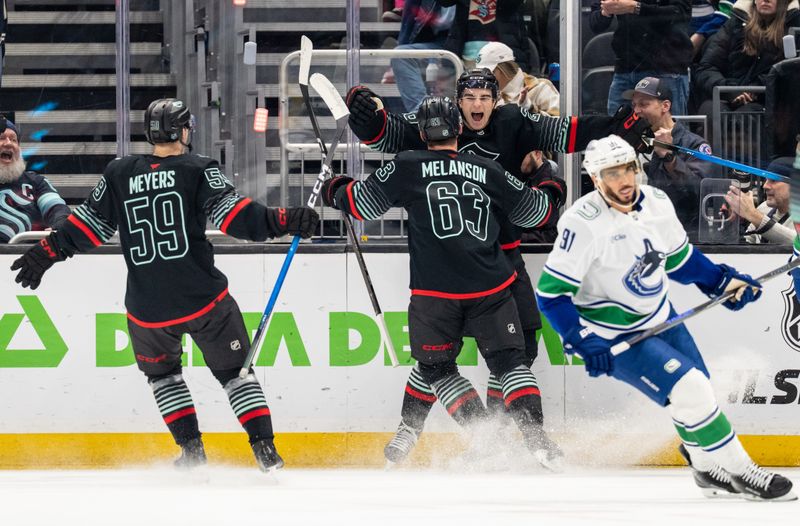 Dec 29, 2025; Seattle, Washington, USA; Seattle Kraken forward Ben Meyers (59), forward Jacob Melanson (63) and forward Ryan Winterton (26) celebrate a goal during the first period against the Vancouver Canucks at Climate Pledge Arena. Mandatory Credit: Stephen Brashear-Imagn Images