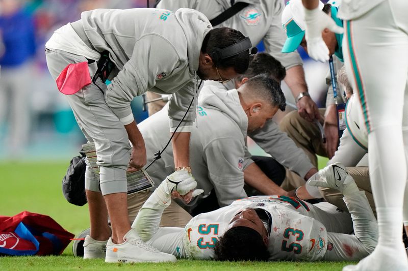 Miami Dolphins head coach Mike McDaniel, left, holds the hand of linebacker Cameron Goode (53) after a play during the second half of an NFL football game against the Buffalo Bills, Sunday, Jan. 7, 2024, in Miami Gardens, Fla. (AP Photo/Wilfredo Lee)