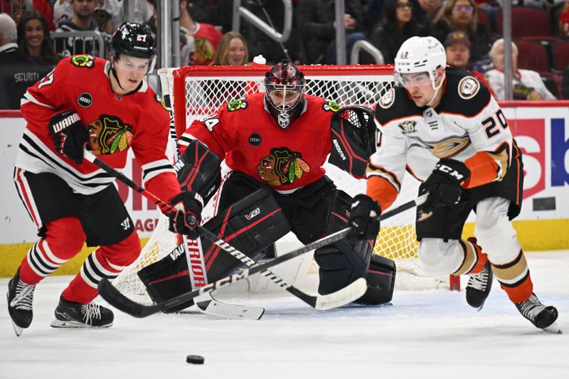 Dec 7, 2023; Chicago, Illinois, USA; Chicago Blackhawks goaltender Petr Mrazek (34) watches the puck as forward Lukas Reichel (27) and Anaheim Ducks forward Brett Leason (20) battle for control in the second period at United Center. Mandatory Credit: Jamie Sabau-USA TODAY Sports