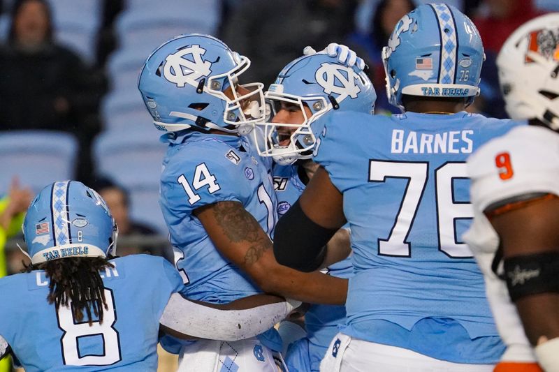 Nov 23, 2019; Chapel Hill, NC, USA; North Carolina Tar Heels wide receiver Emery Simmons (14) celebrates his first half touchdown catch with North Carolina Tar Heels quarterback Sam Howell (7) against the Mercer Bears at Kenan Memorial Stadium. Mandatory Credit: James Guillory-USA TODAY Sports